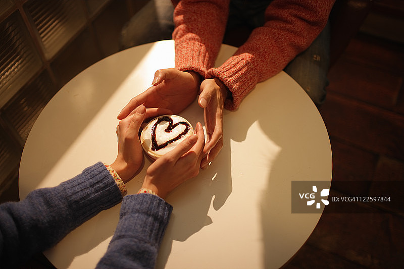 情侣手捧卡布奇诺咖啡图片素材