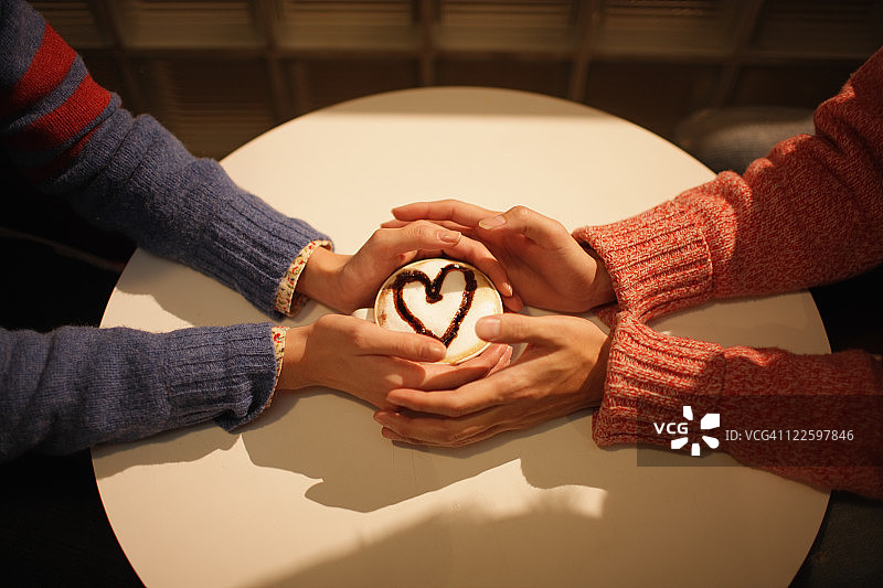 情侣手捧卡布奇诺咖啡图片素材