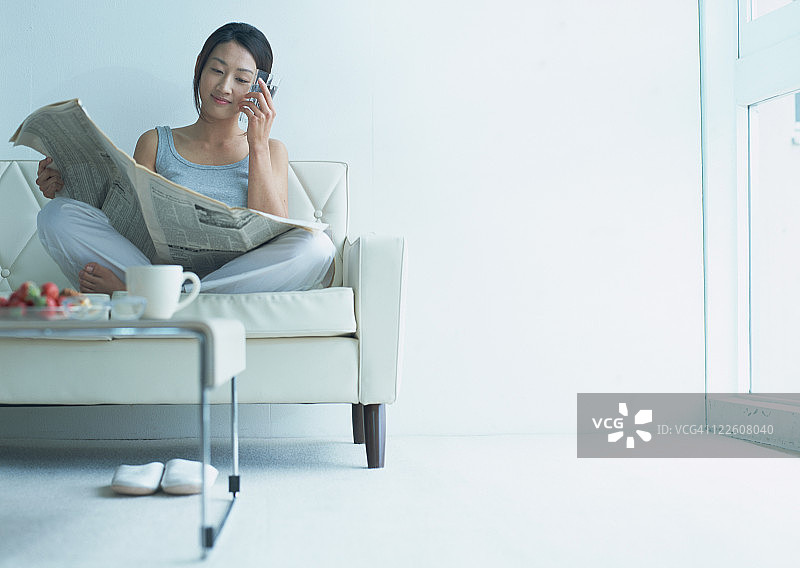 在地板上看报纸的女人图片素材