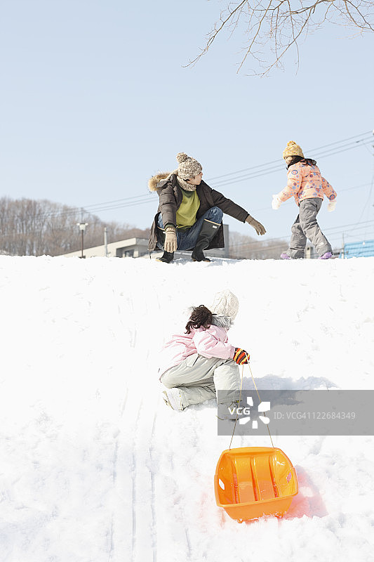父子和孩子们玩雪橇图片素材