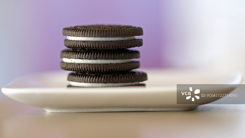 堆叠在白色小盘子上的三块饼干图片素材