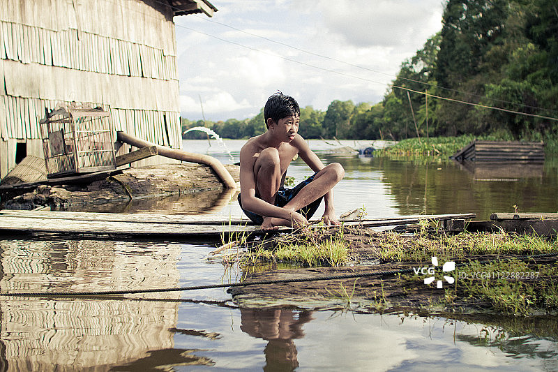 男孩在河里钓鱼图片素材