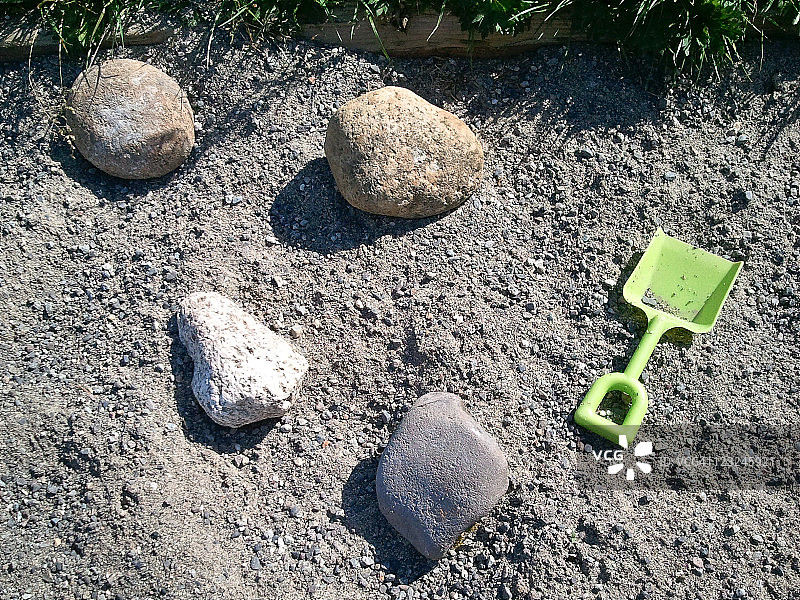 四块岩石和绿色铲子图片素材