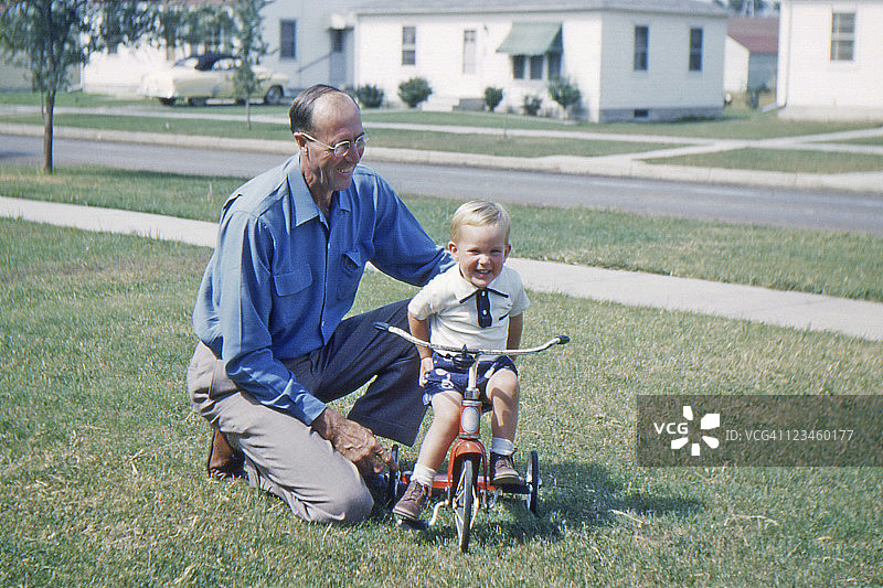 爷爷教孙子骑三轮车，1953年，复古图片素材