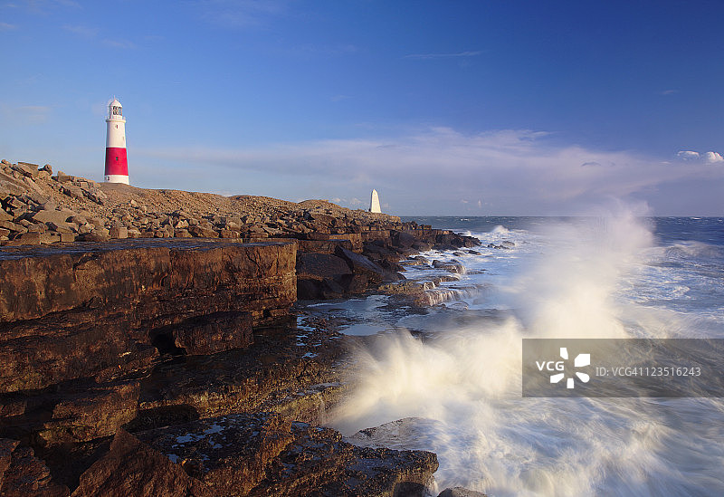 海浪拍打多塞特郡波特兰比尔灯塔附近的岩石图片素材