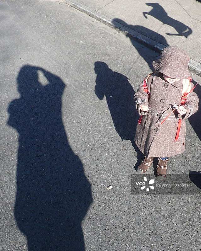 站在有阴影的道路上的女孩图片素材
