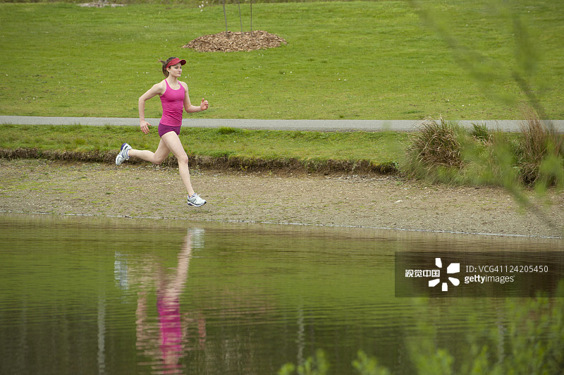 混血女人在池塘附近跑步图片素材