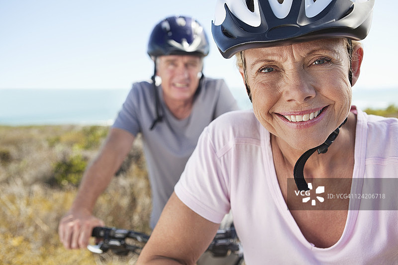 体育头盔中年妇女的微笑画像，背景是男人图片素材