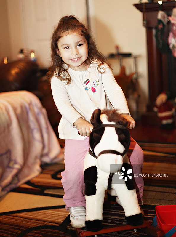 摇马上蹒跚学步的女孩图片素材