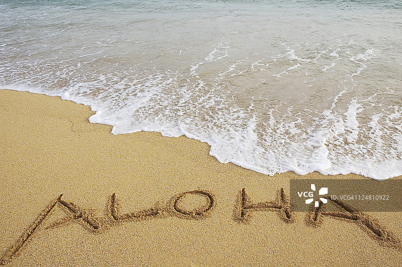 海浪冲刷沙滩上的Aloha字样图片素材