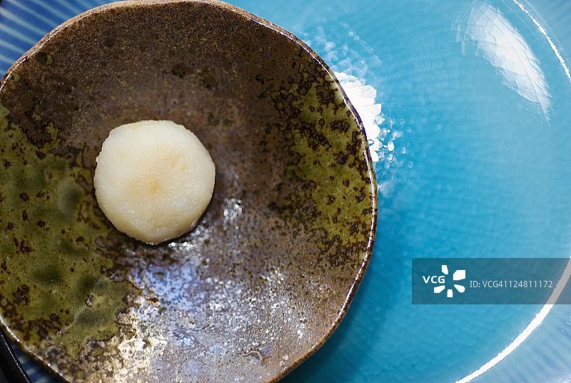 放在棕色盘子上，蓝色盘子上的荸荠特写图片素材