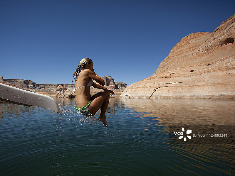 美国犹他州：年轻女子跳入鲍威尔湖图片素材