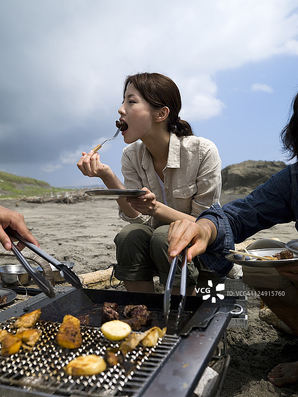 食欲好的女人吃烤肉图片素材