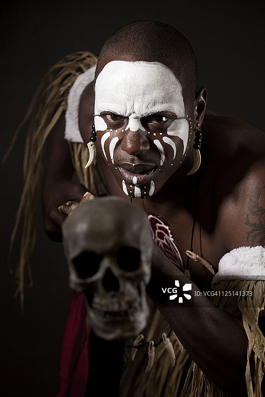 在戏剧性光线下涂有身体彩绘的非洲巫医图片素材
