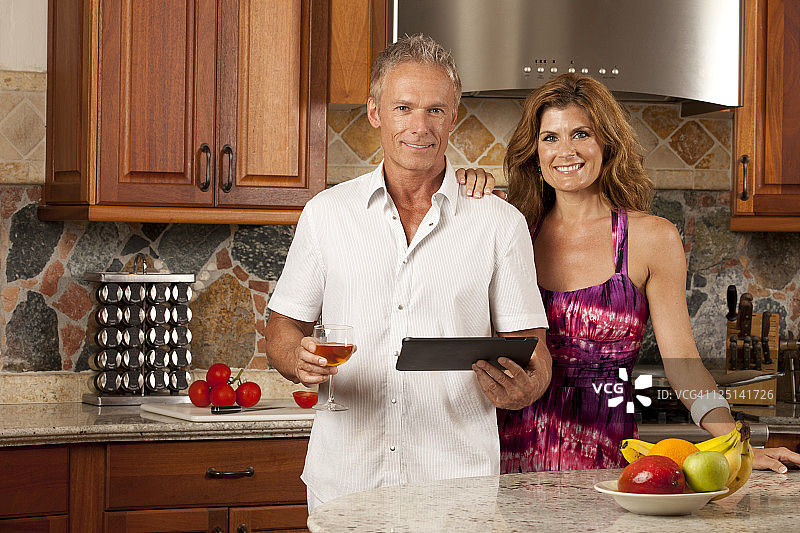 情侣在厨房使用平板电脑图片素材