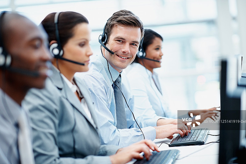 办公室里戴着耳机的客服支持团队图片素材