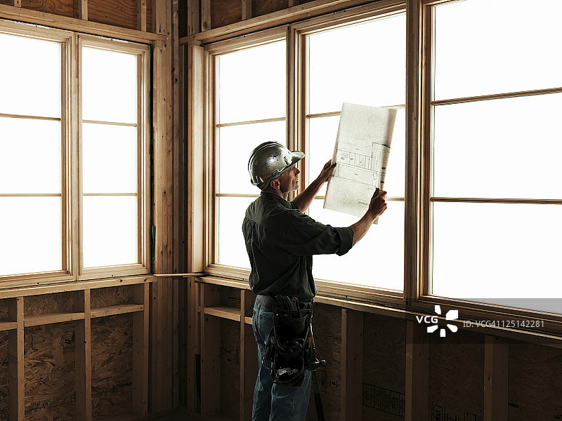 建筑工人在窗前看蓝图图片素材