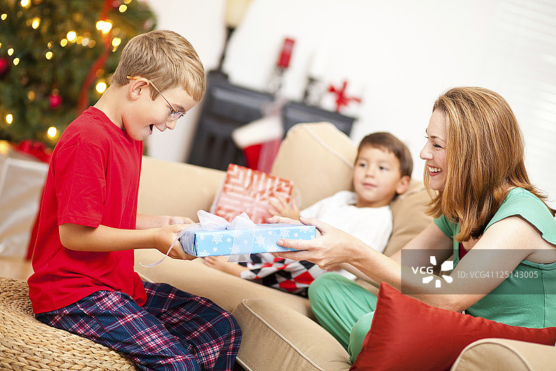 圣诞节男孩收到妈妈的礼物图片素材