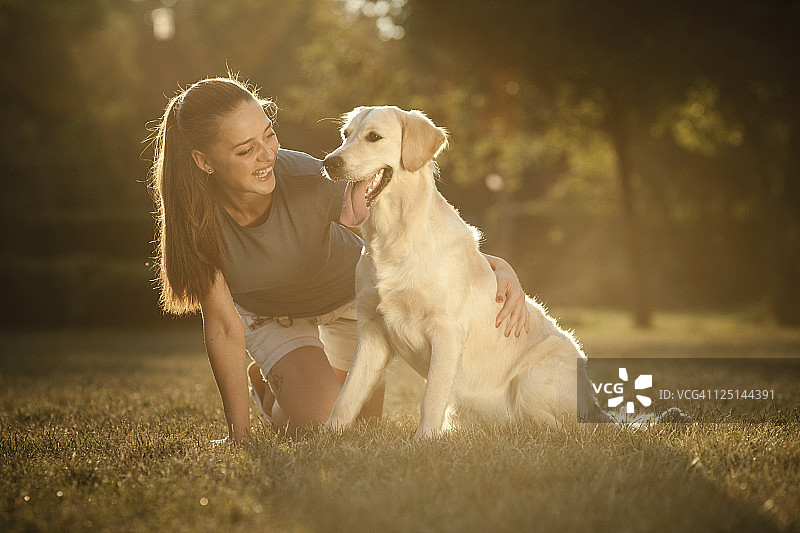 在公园里和她的狗在一起的少女图片素材