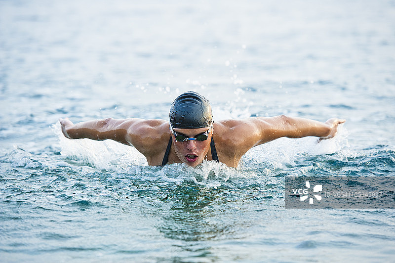 在海中蝶泳的女游泳运动员图片素材