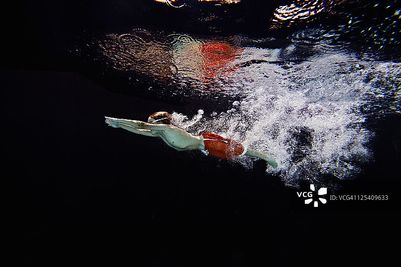 跳入泳池的年轻男游泳者图片素材