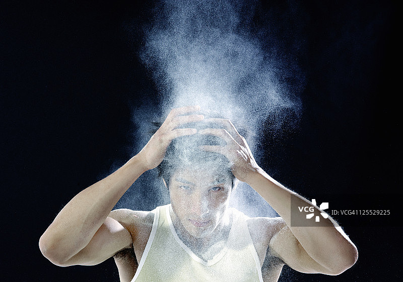 男人抖落头发上的头皮屑粉末图片素材