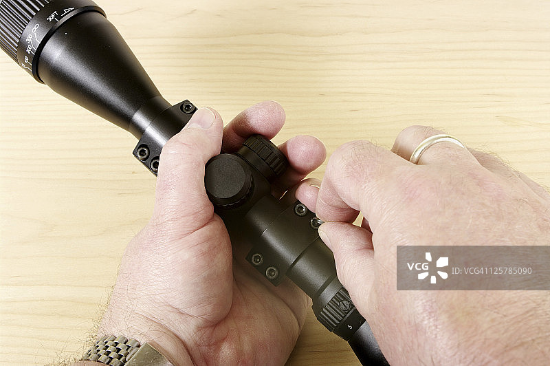 男人手持瞄准镜调整支架图片素材