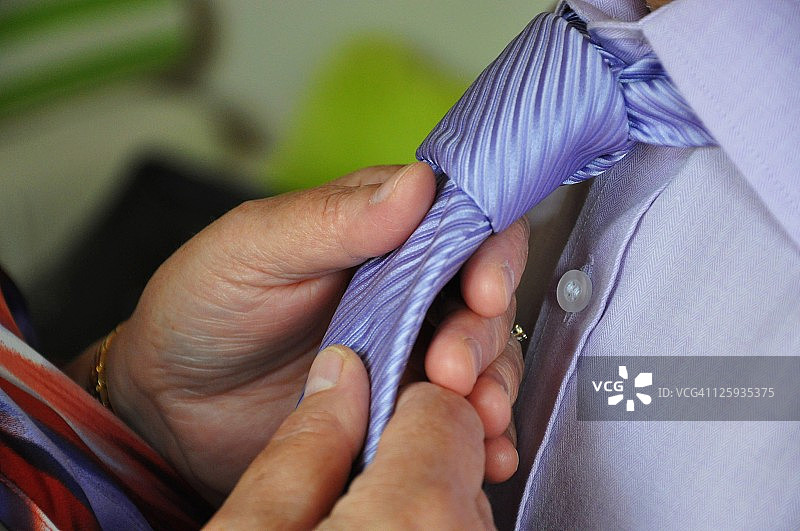 整理领带的老年人的手图片素材