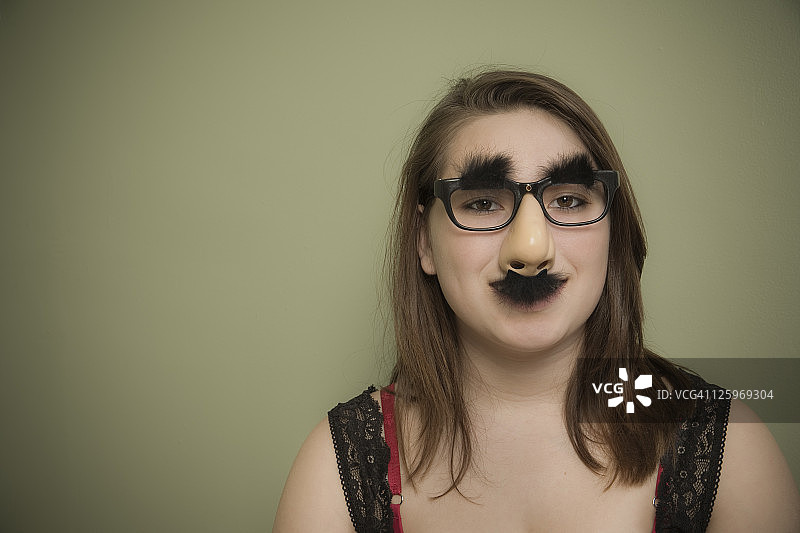 戴着滑稽伪装的15岁白人女性图片素材