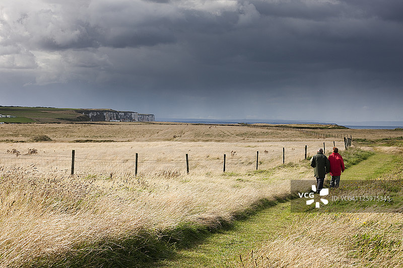 在英国东约克郡弗兰伯勒角高地遗产海岸的悬崖上行走的人图片素材