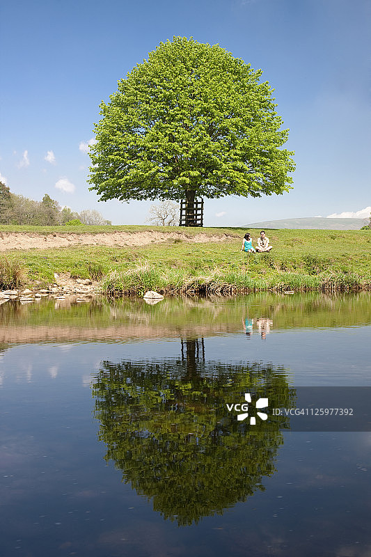 情侣坐在英国兰开夏郡博兰森林霍德河边图片素材