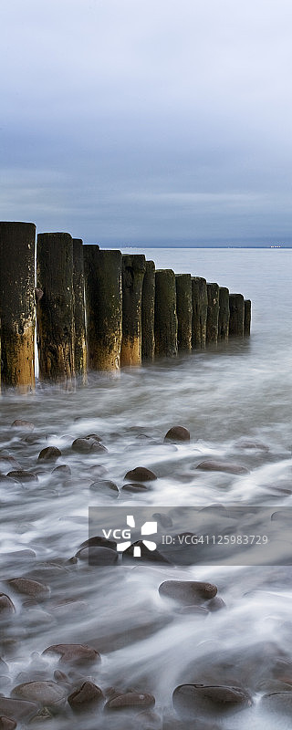 英国萨默塞特郡米恩黑德海滩的木制防沙堤和退潮图片素材