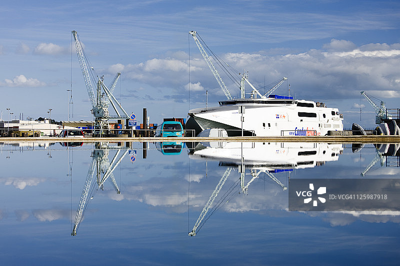 根西岛模型船池中的高速水翼船和码头起重机倒影，海峡群岛图片素材