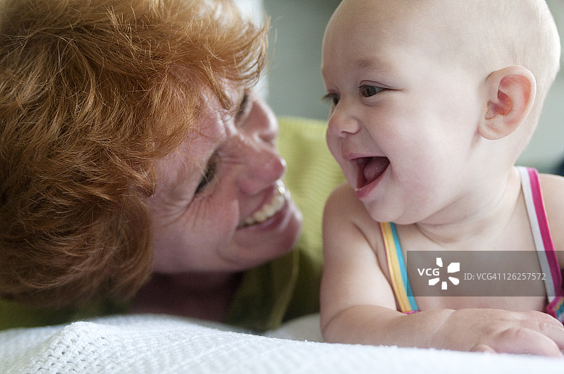 和婴儿玩耍的年长女人图片素材