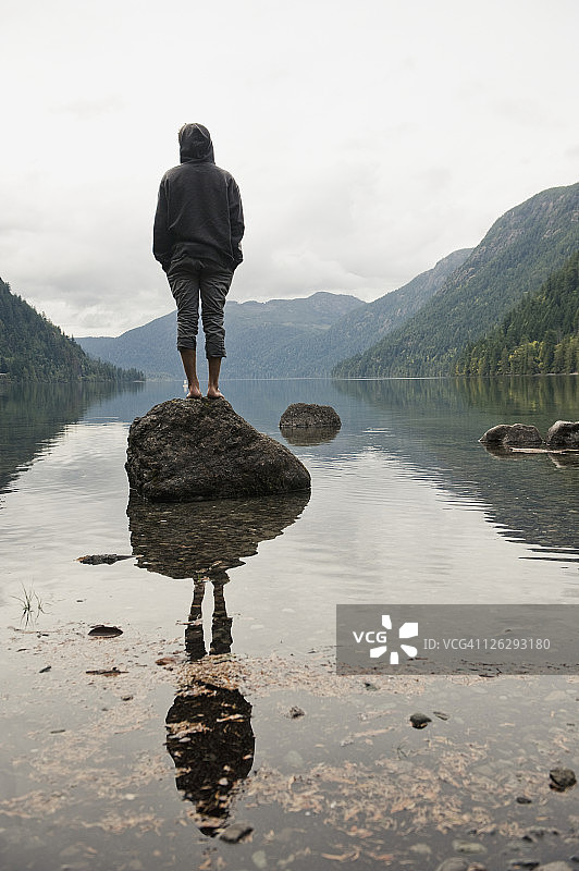 一位站在卡梅伦湖岩石上的年轻男人图片素材