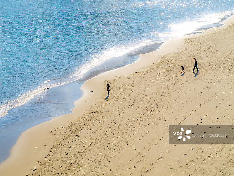 男人和两个孩子在海边散步图片素材