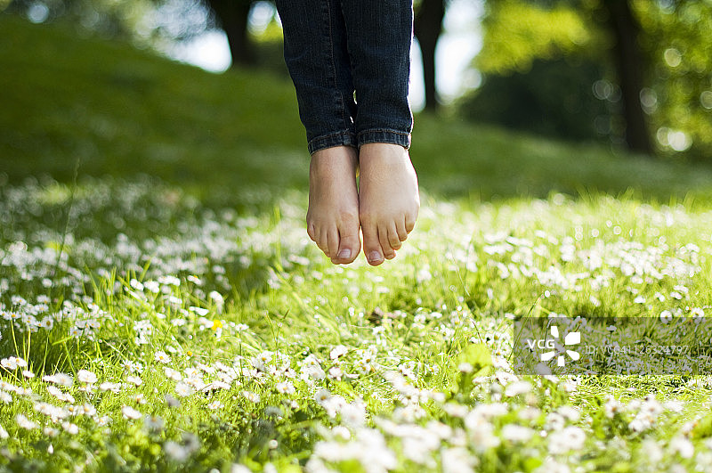 在公园里跳跃的女孩，双脚悬空图片素材