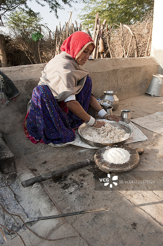 在印度拉贾斯坦邦，比什诺伊族妇女用传统方法制作薄饼图片素材