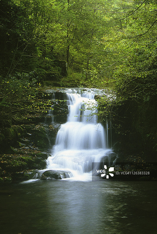 德文郡埃克斯穆尔国家公园Watersmeet附近岩石上倾泻而下的瀑布图片素材