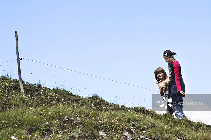 母亲和女儿在蓝天下的田野上图片素材