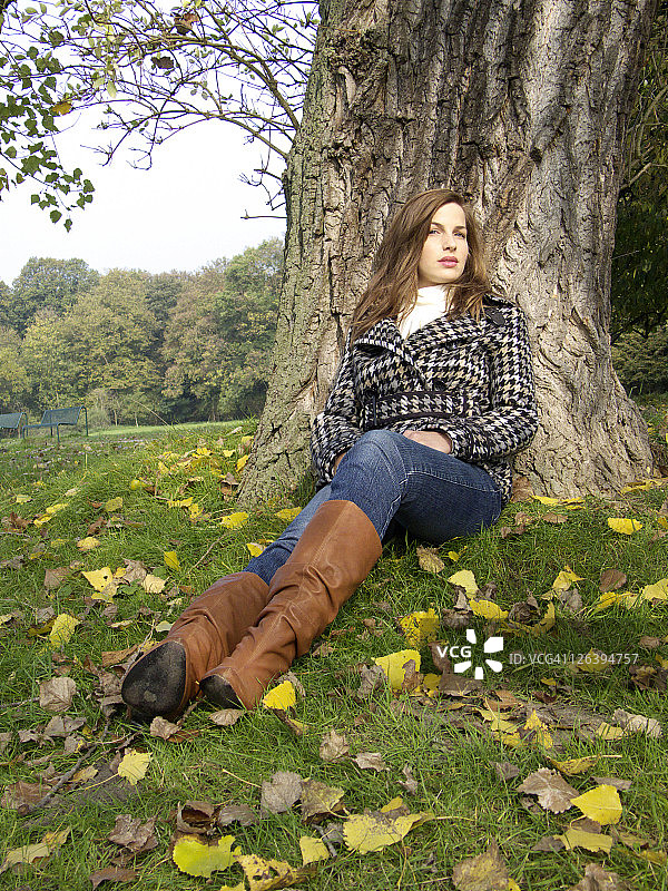 坐在树干上的年轻女子的画像图片素材