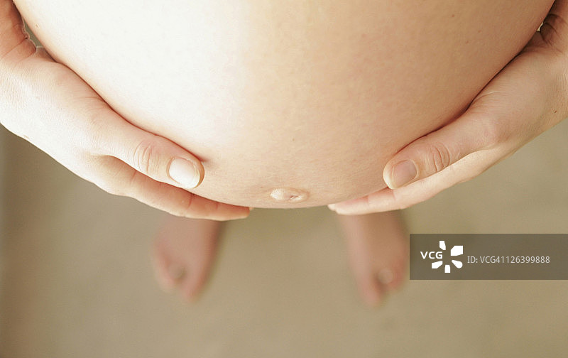 手放在肚子上的女人图片素材