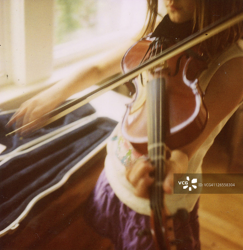 在窗边拉小提琴的女孩图片素材