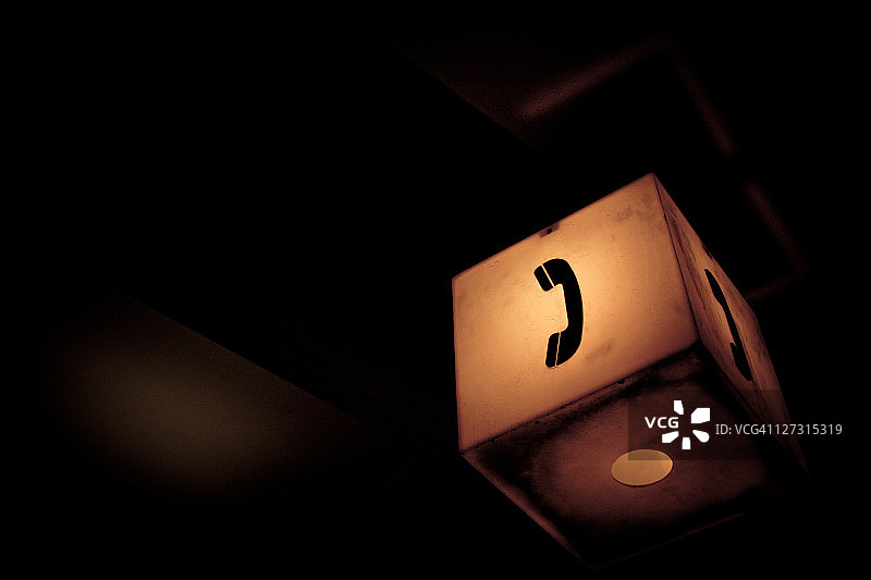 黑暗区域中点亮的电话亭标志图片素材