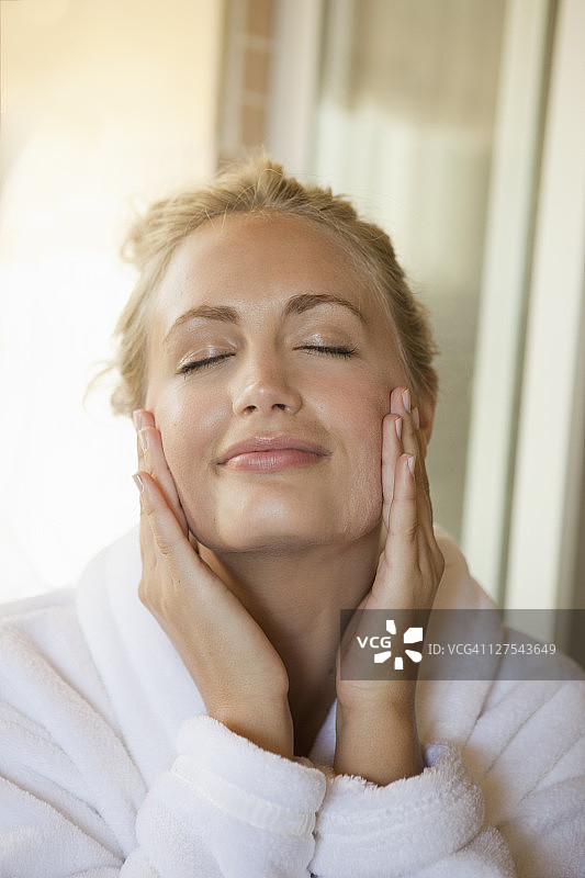 女人在脸上涂抹润肤霜图片素材