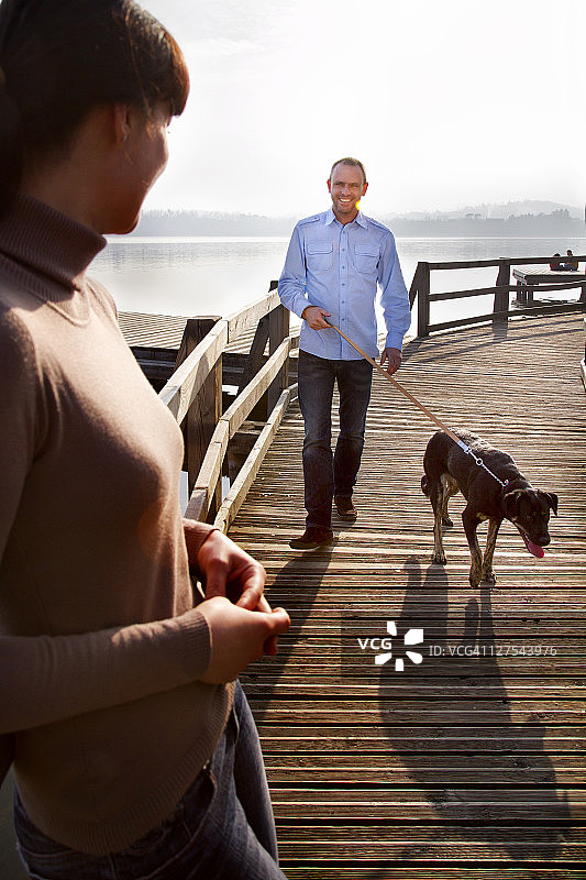 情侣在码头上遛狗图片素材