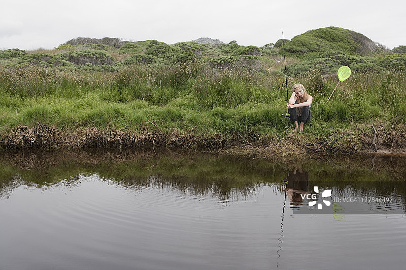 女孩在小溪里用网捕鱼图片素材
