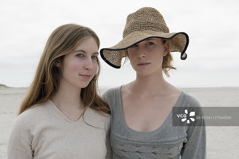 女人并肩站立在沙滩上图片素材