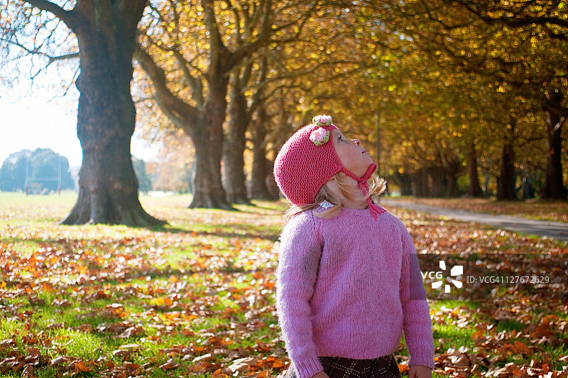 女孩欣赏基督城哈格利公园的秋叶图片素材