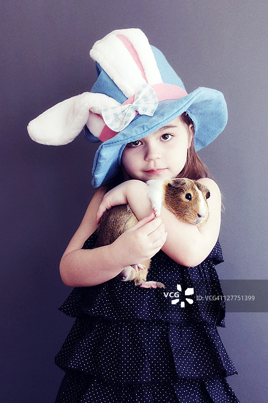 头戴帽子手 Holding animal 的女孩图片素材